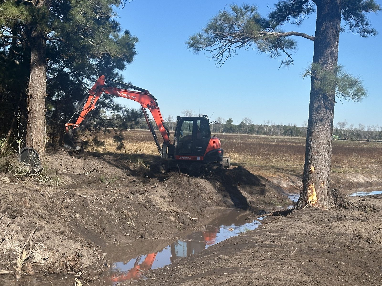 Kubota KX080 excavator digging a stream channel